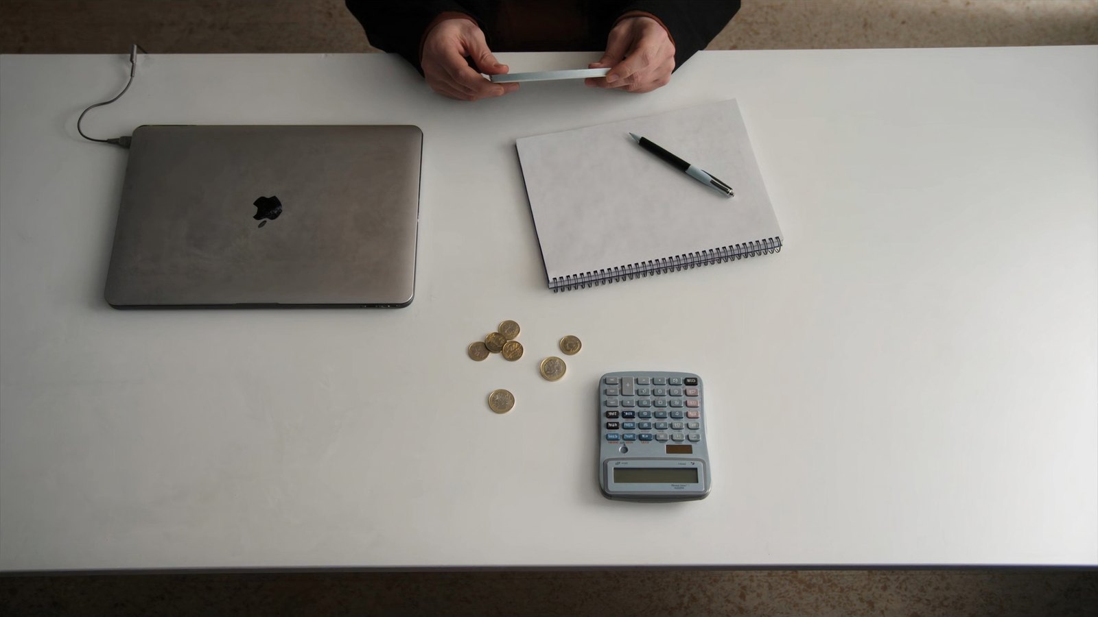 Bureau avec ordinateur, calculatrice et pièces de monnaie — combien coûte vraiment un site internet