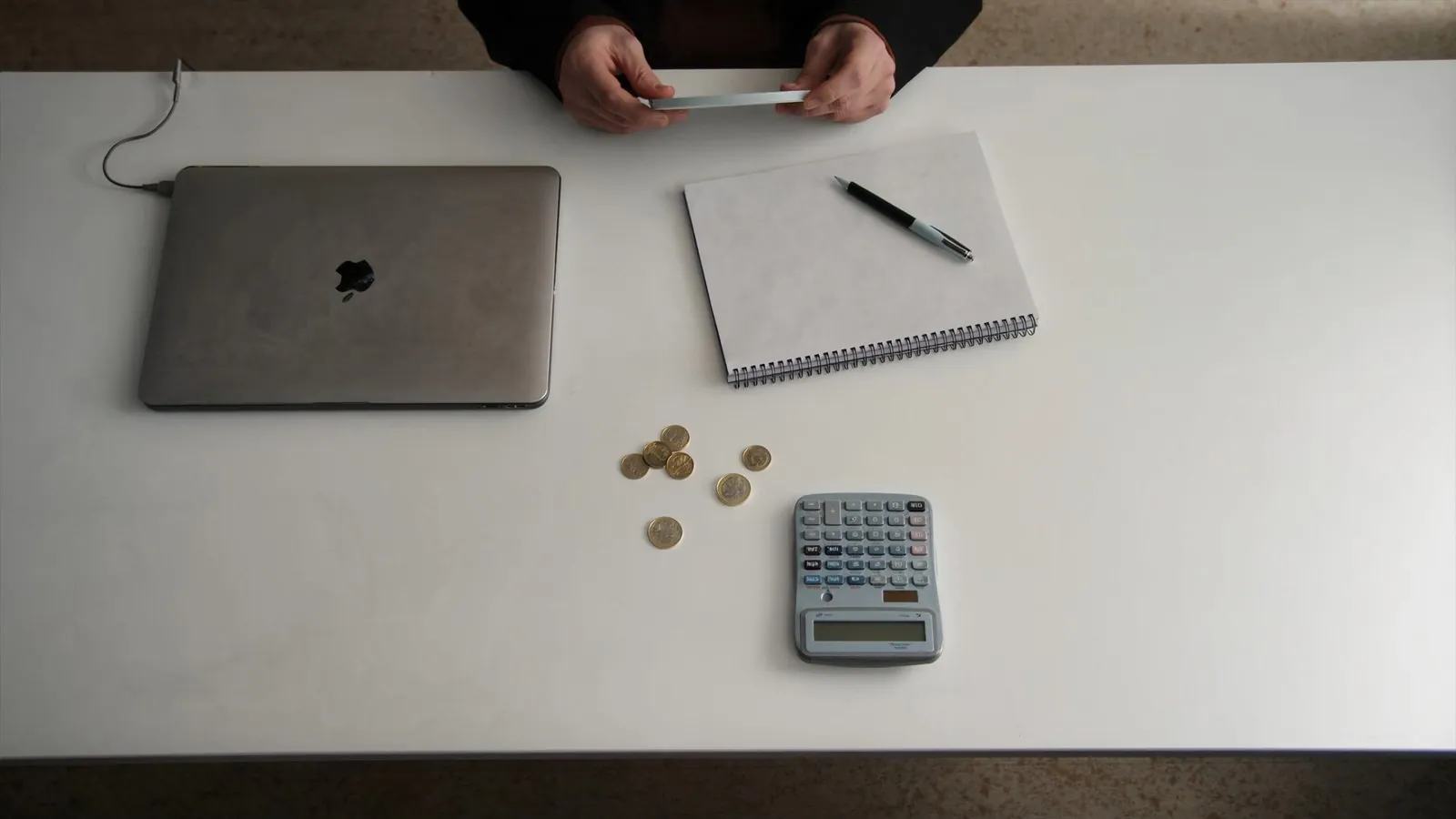 Bureau avec ordinateur, calculatrice et pièces de monnaie — combien coûte vraiment un site internet